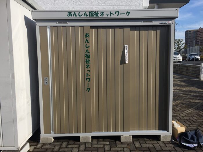 倉庫に緑のカッティングシートを貼り付け