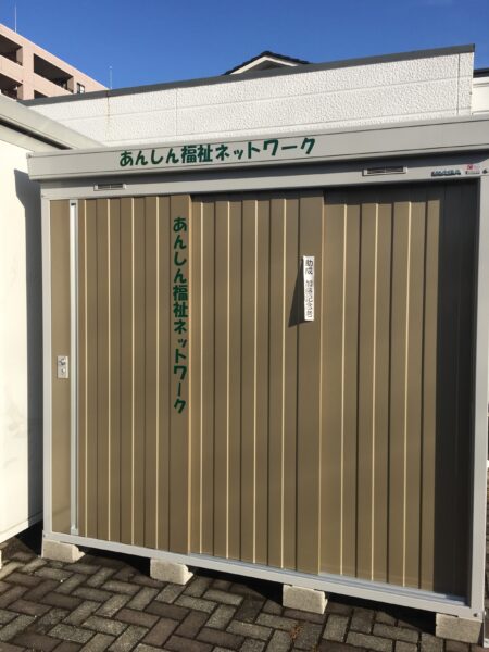 倉庫に緑のカッティングシートを貼り付け